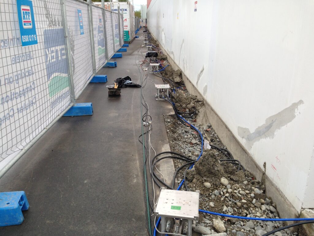 大型建物の沈下修正現場で注入装置の配置を管理する様子